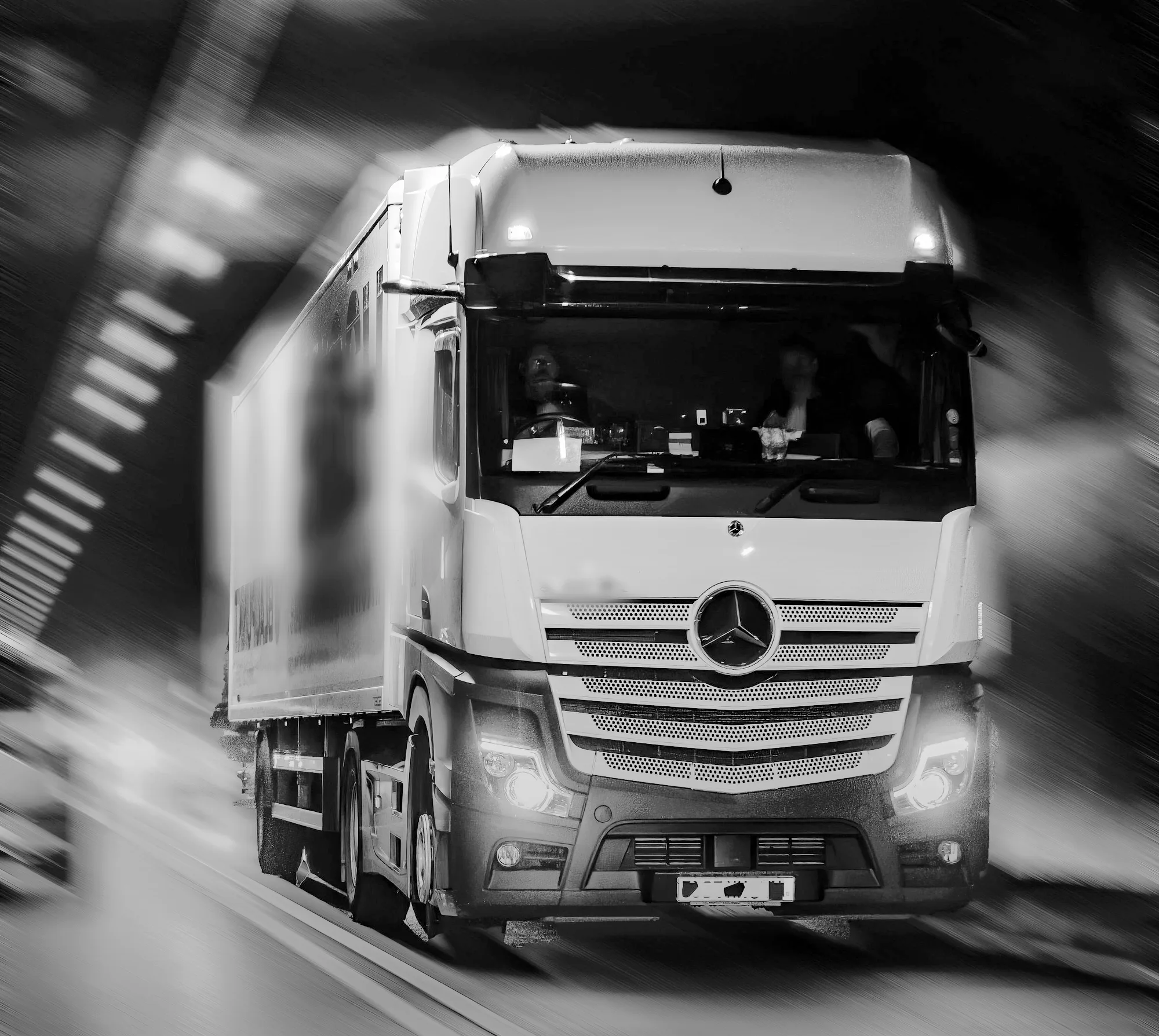 Articulated truck driving at speed with headlights on